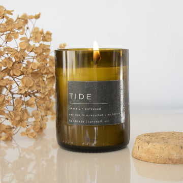 Tide candle set in a recycled wine bottle jar and finished with a cork lid.  Fragrance - Sea Salt + Driftwood  Wax - Vegan coconut & soy  Inspired by nature, handmade in Cornwall.