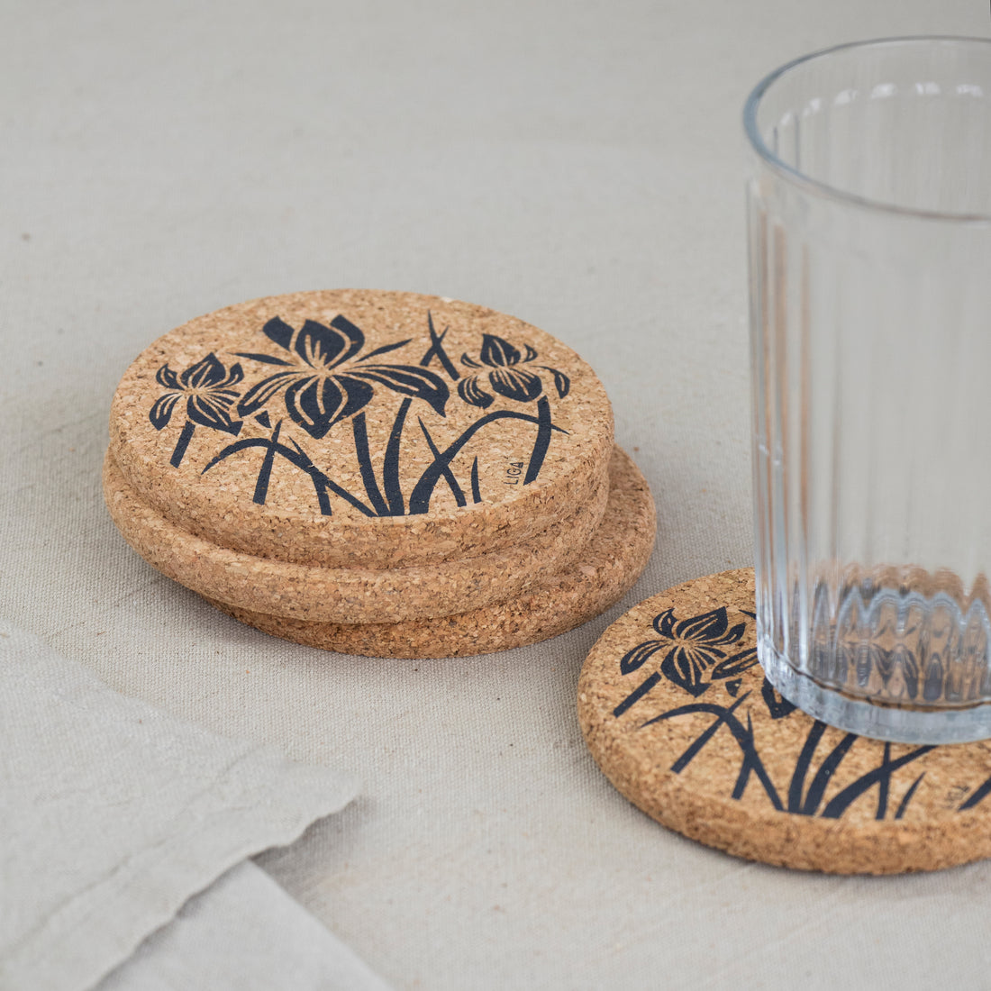 cork coaster with Iris design on table with glass